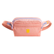 The Alpha 360 Hip Pack Salmon Pink is a pastel pink rectangular waist bag with a lavender zipper, front pocket, adjustable strap, and a small yellow patch with the logo on the front.